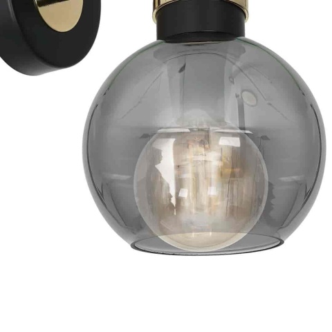 OMEGA BLACK/GOLD - detal złotego pierścienia nad kloszem