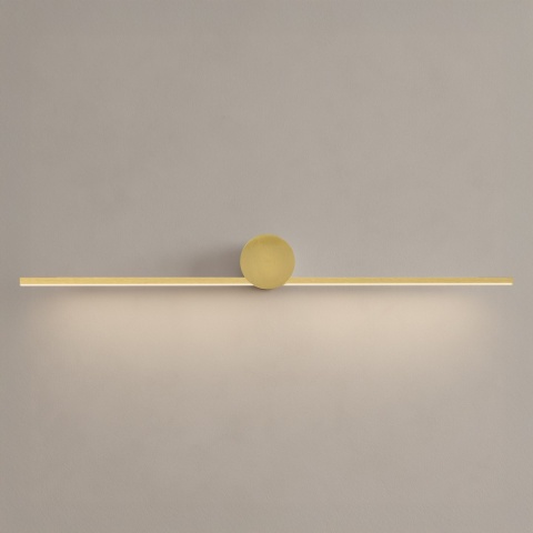 Kinkiet ARTIST złoty 9W LED 60cm - podłużna oprawa z włączonym światłem na ścianie